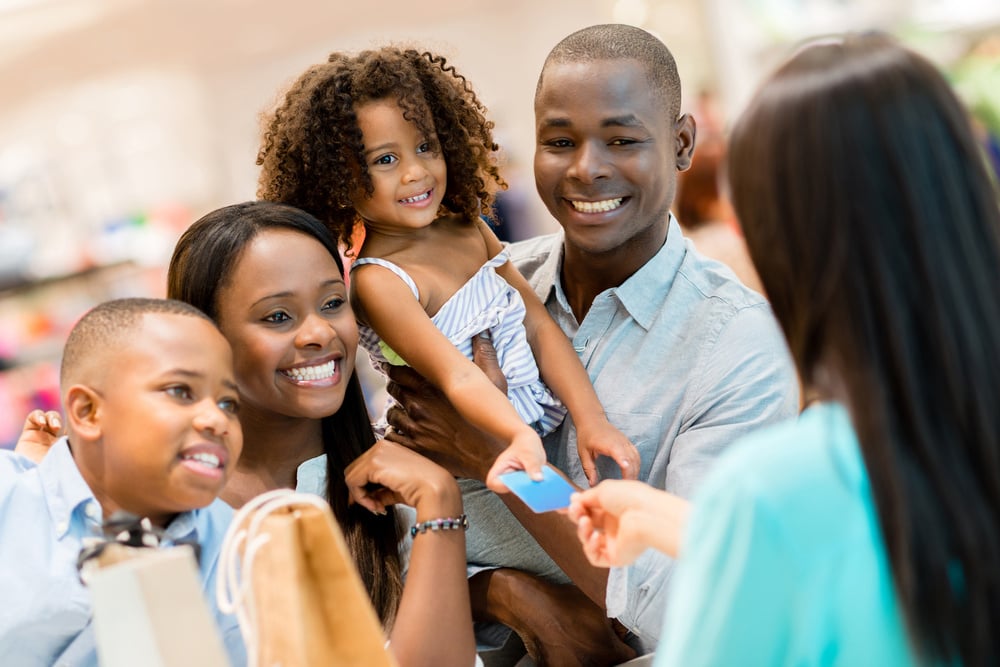 Happy shopping family at the cashier paying for their purchases