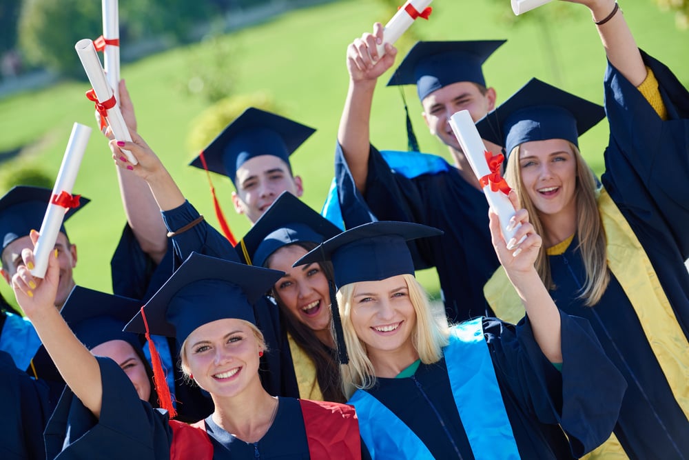 young graduates students group  standing in front of university building on graduation day